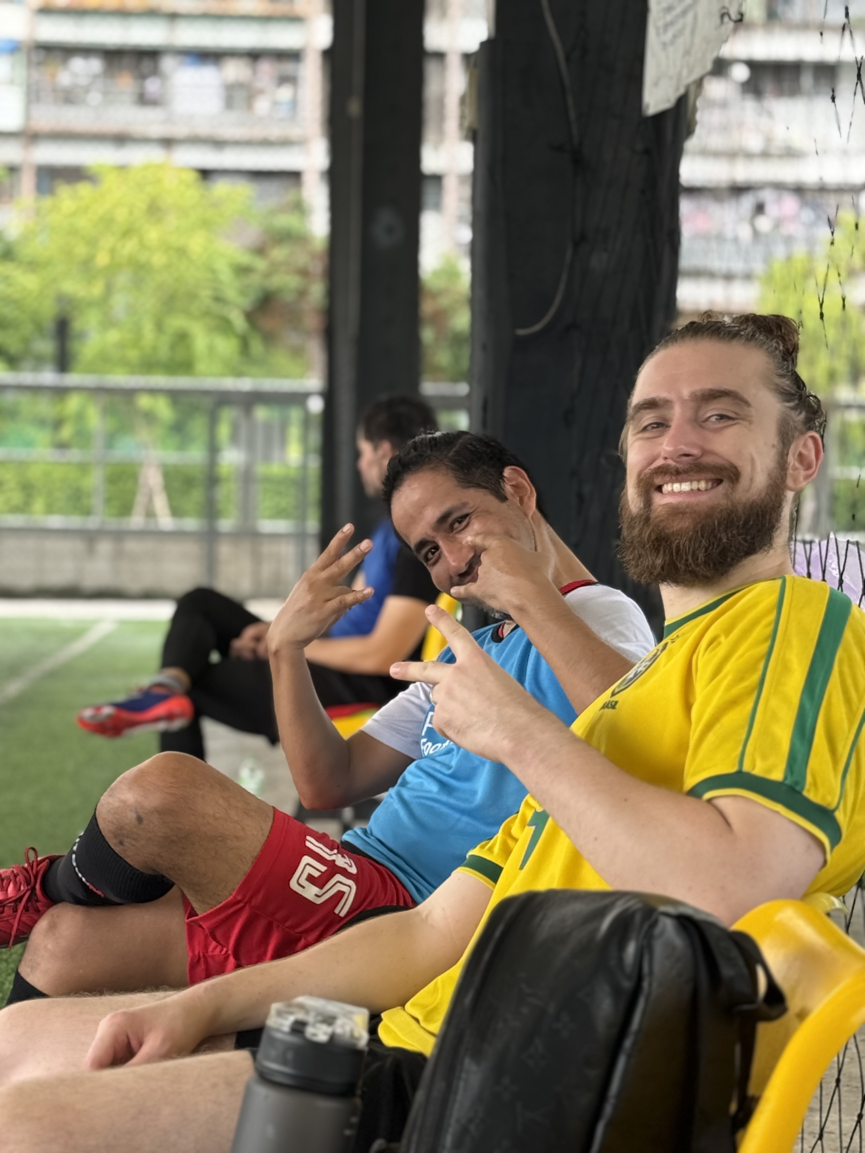 Expat players socializing after a pickup football game in Bangkok
