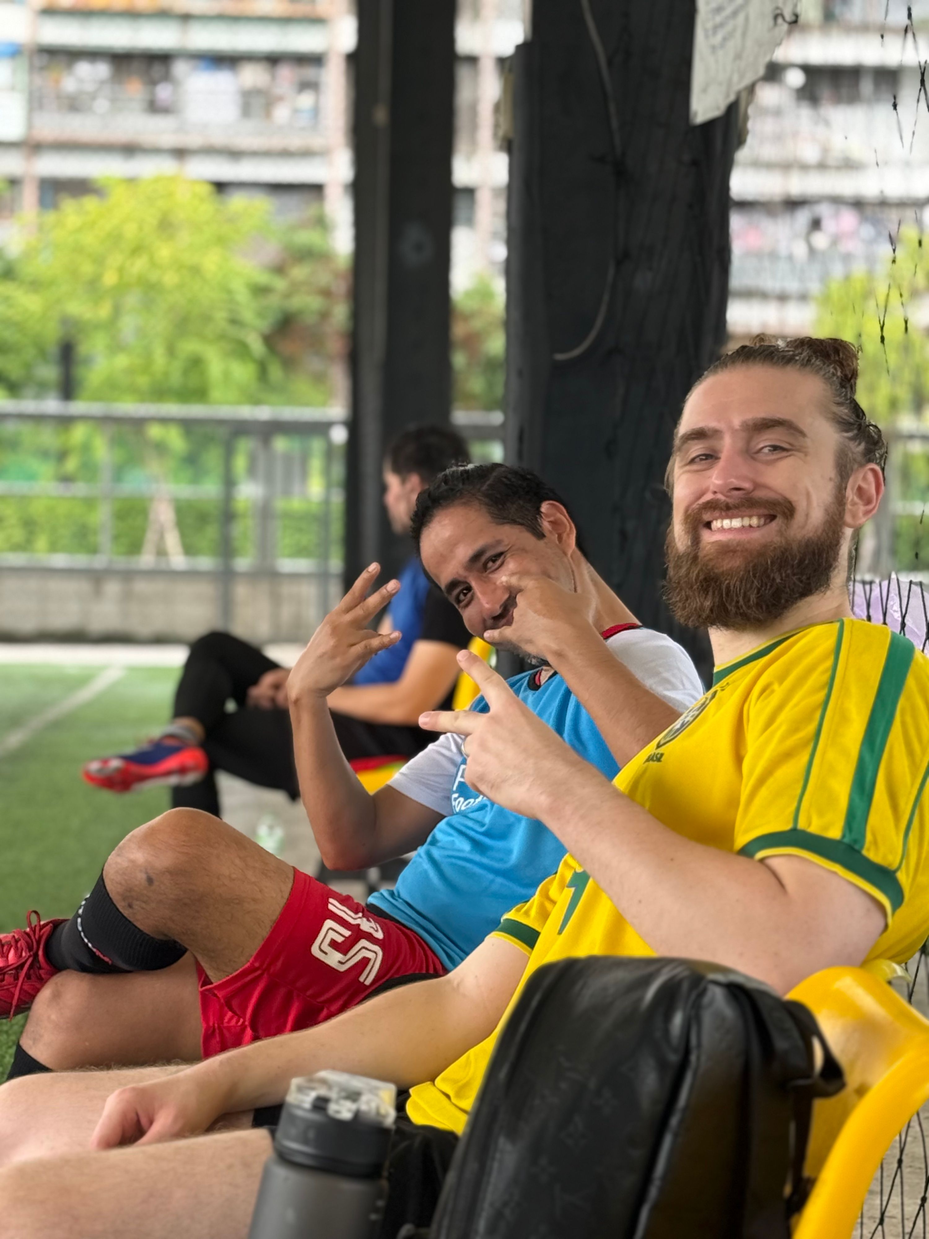 Expat players socializing after a pickup football game in Bangkok