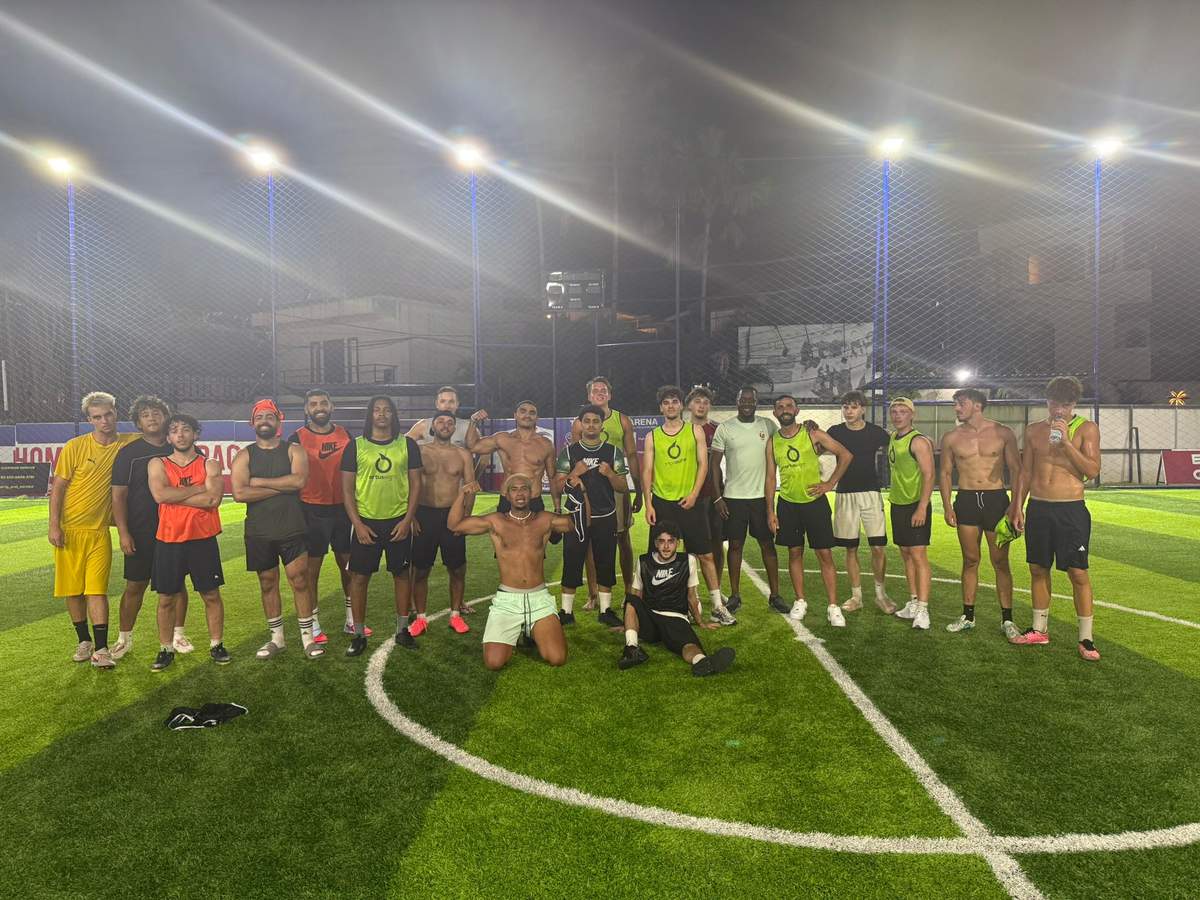 A diverse group of expat and local players together after an evening pickup football game in Southeast Asia