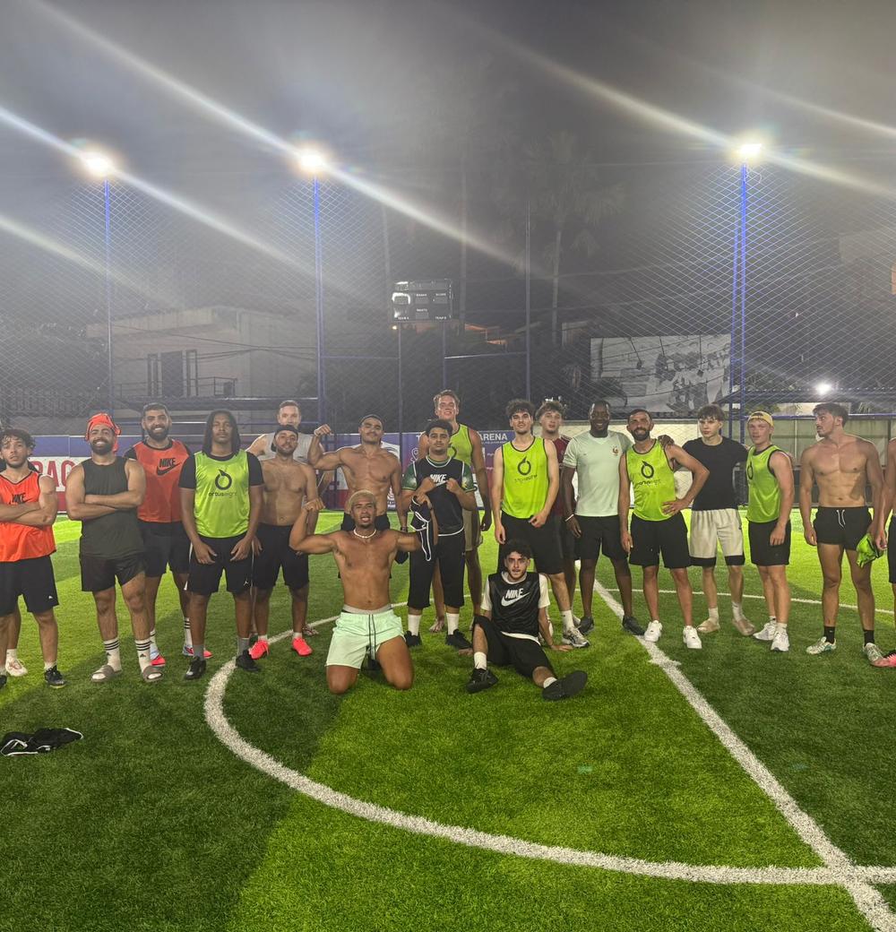 A diverse group of expat and local players together after an evening pickup football game in Southeast Asia